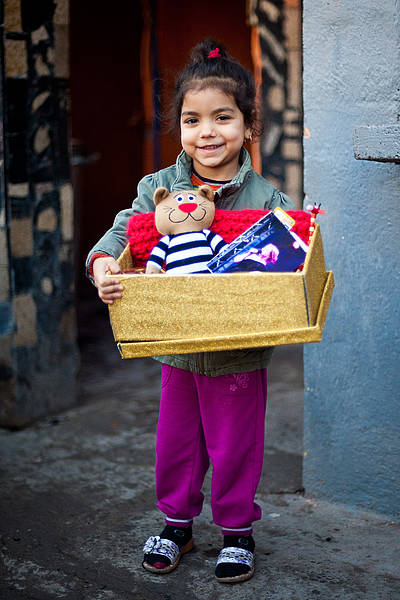 Ein Maedchen zeigt stolz ihren Schuhkarton